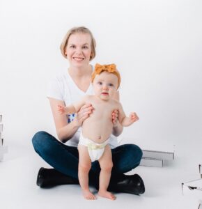 Rebecca with baby and pizza boxes photo credit The Malicotes - fouth trimester podcast - postpartum recovery